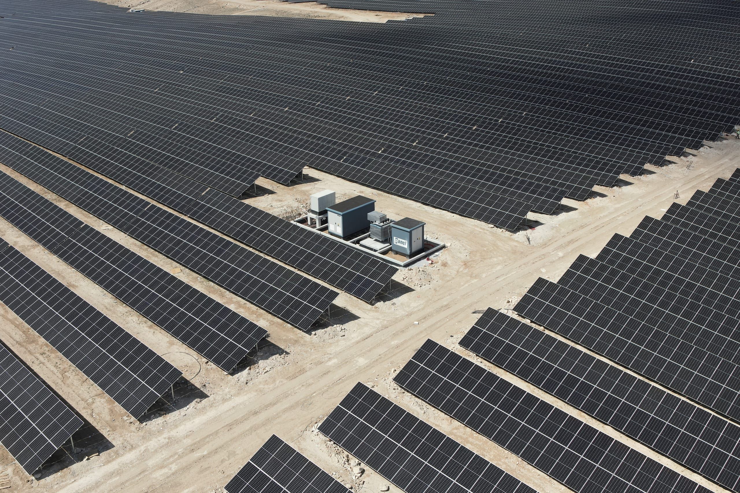 Güneş enerjisi santralinde panel dizileri arasına kurulmuş Panel Elektrik trafo köşkü, havadan görünüm